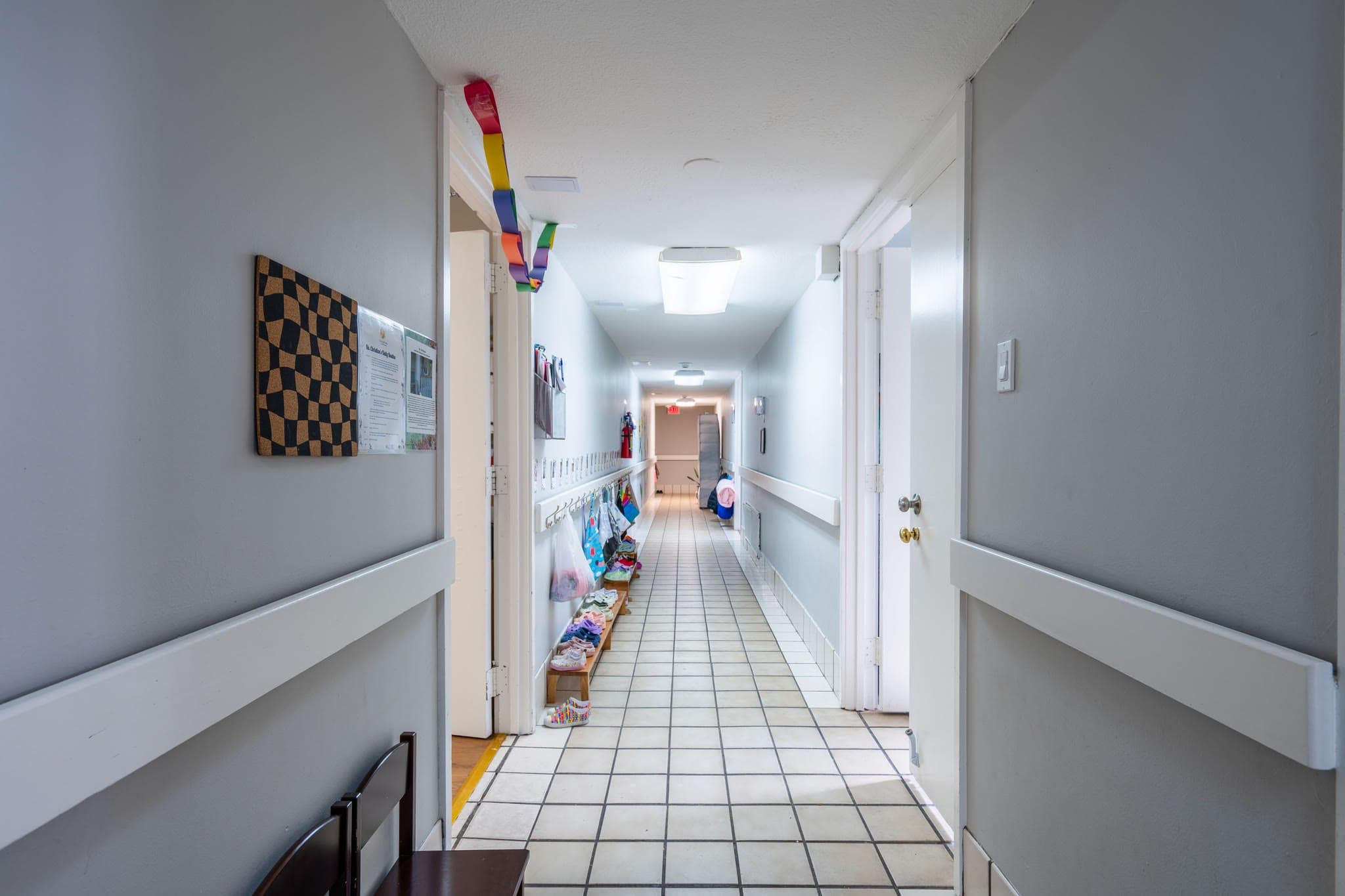 A hallway lined with children's cubbies and belongings
