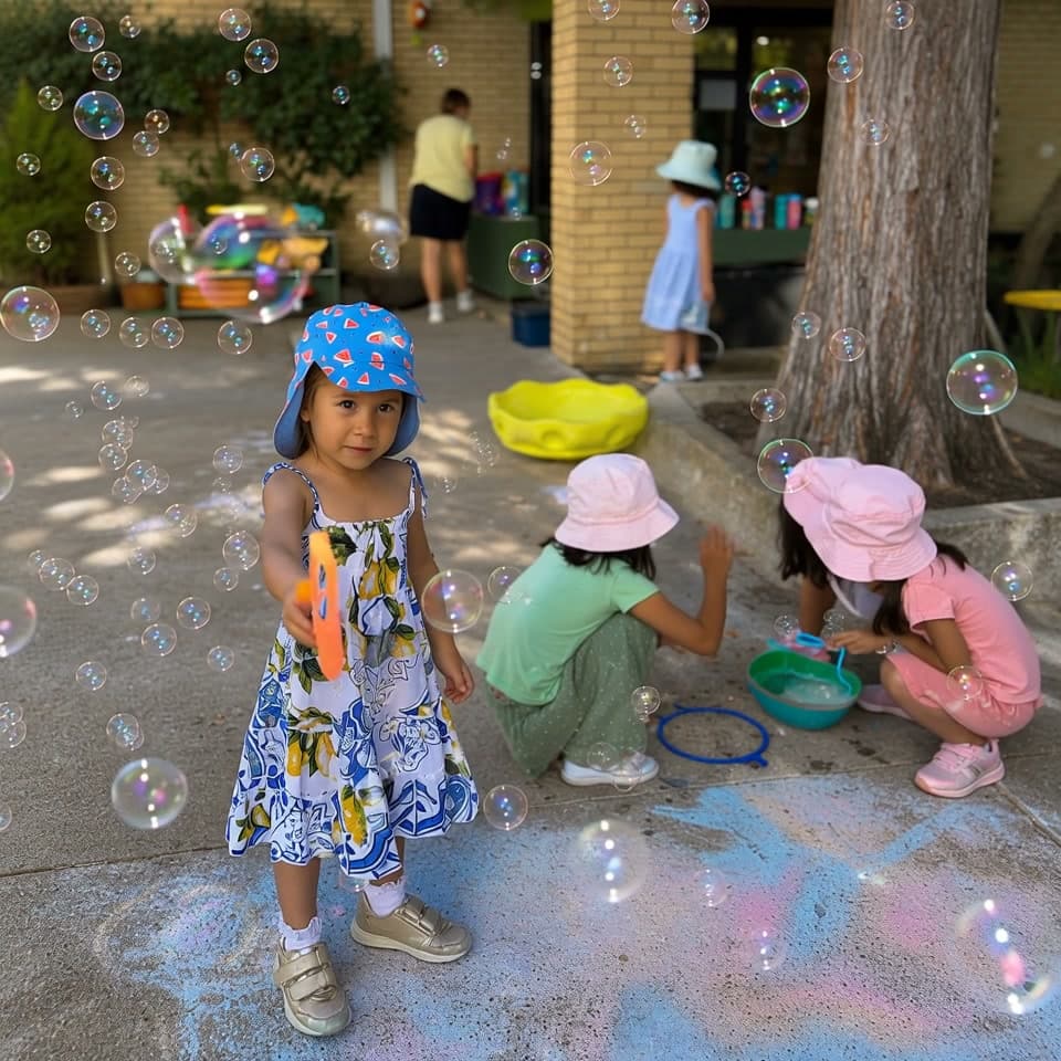 Campers blowing bubbles together in the courtyard on a sunny afternoon